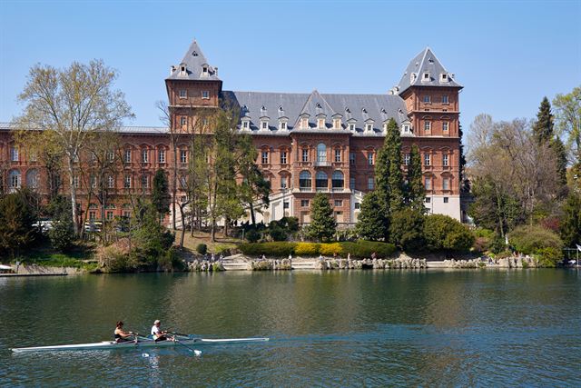 Rowers on the Po in front of the red-brick Valentino Castle, Turin