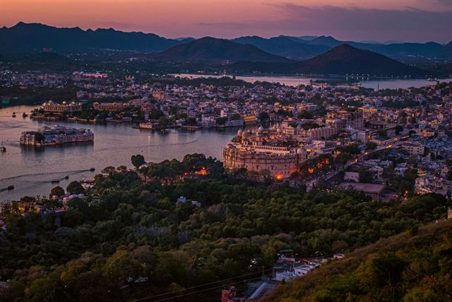 Udaipur at dusk with Lake Pichola, the Lake Palace hotel and City Palace among hills