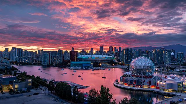 Vancouver skyline, BC Place and the Science World dome on False Creek under a vivid pink sunset