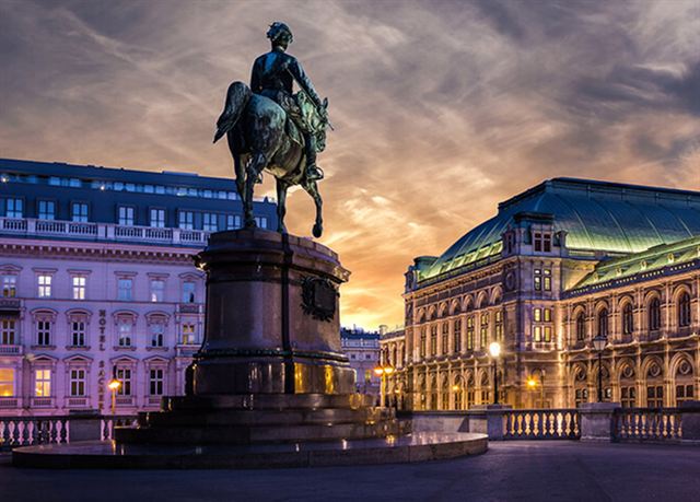 Equestrian statue by the Albertina with the Vienna State Opera behind at dusk