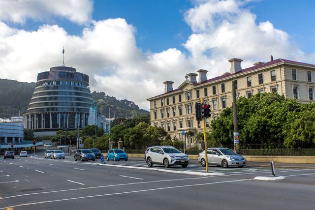 The Beehive parliament building and historic Parliament Library in Wellington under blue sky