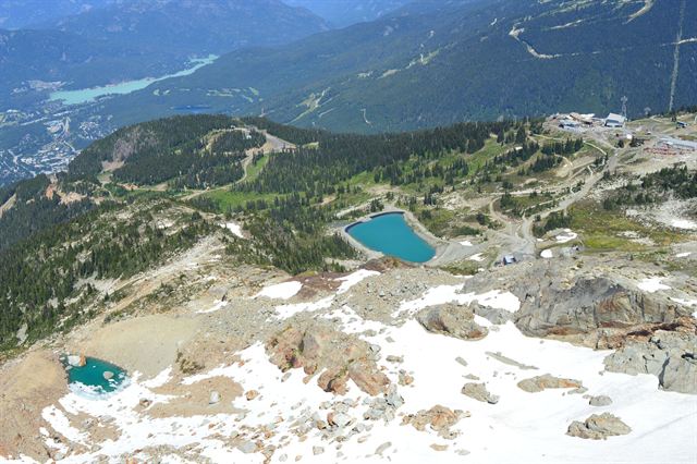 Aerial view of Whistler Mountain's alpine lakes, snow patches and green valley with lakes below
