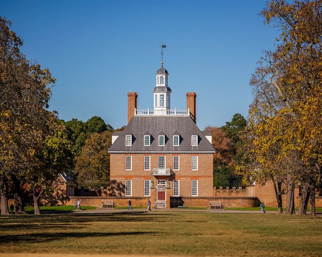 Brick Governor's Palace with its cupola in Colonial Williamsburg framed by autumn trees