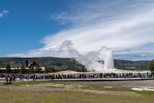 Crowd watching Old Faithful erupt behind the boardwalk in Yellowstone
