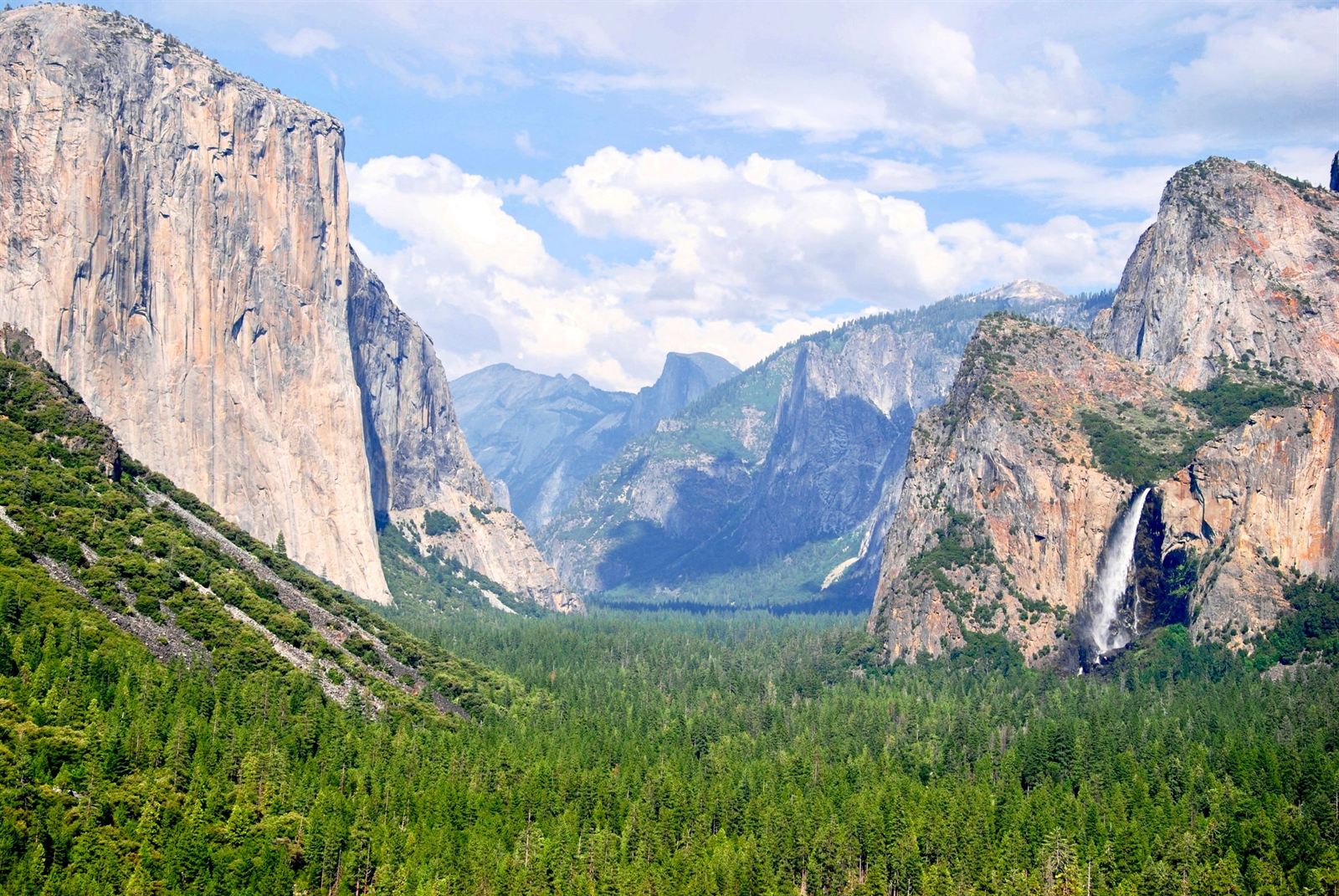 Tunnel View in Yosemite Valley showing El Capitan, Bridalveil Fall and Half Dome above green forest
